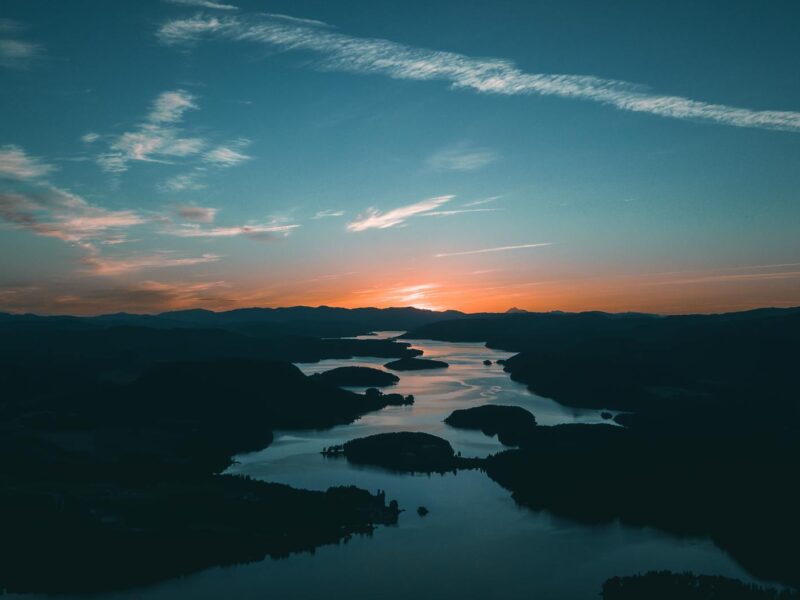 aerial photography of water beside forest during golden hour